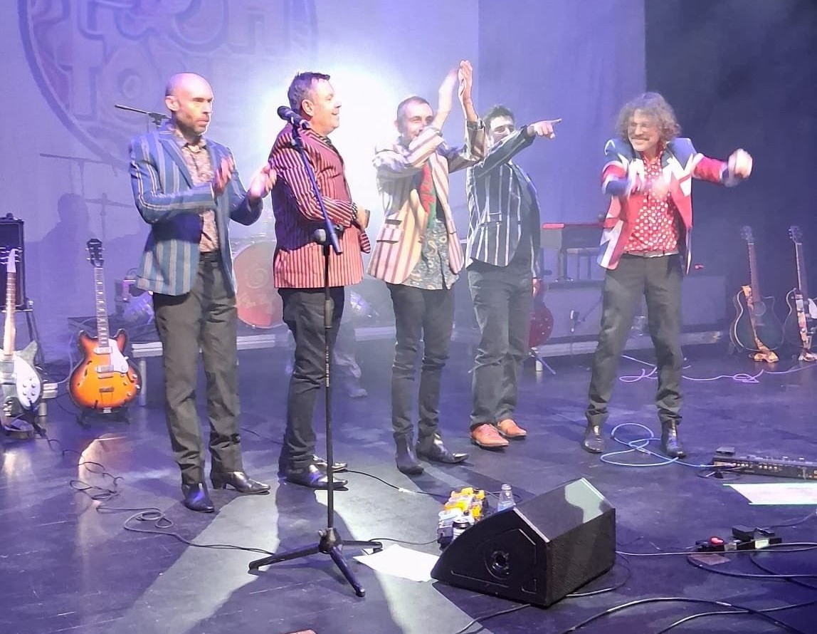 All five band members lined up taking a bow to applause at the end of the show